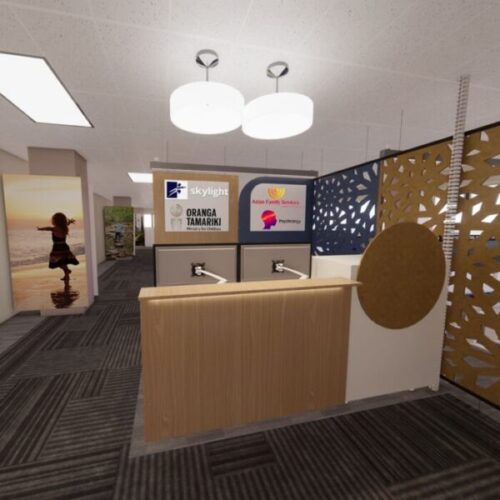 Shared social services reception desk with signage for “skylight,” “Oranga Tamariki Ministry for Children,” and “Asian Family Services Psychology,” plus decorative privacy screens and office workstations.